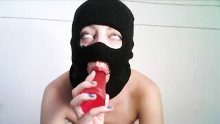 Masked teen giving a blowjob to a dildo