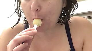 Bored mom with banana popsicle sucking on it