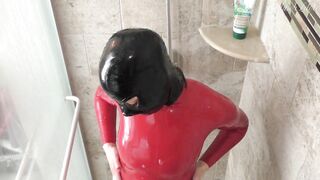 Rubberdoll showers in red catsuit