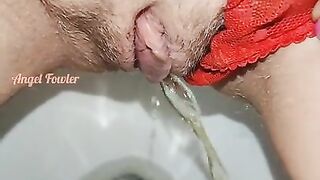 Delicious piss with red panties pushed aside in the toilet